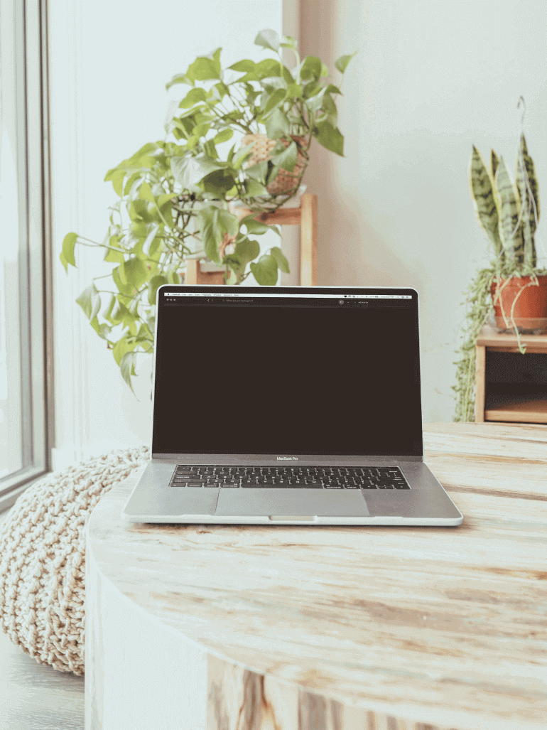 Laptop auf einem Tisch mit einem Sitzsack an der Seite.